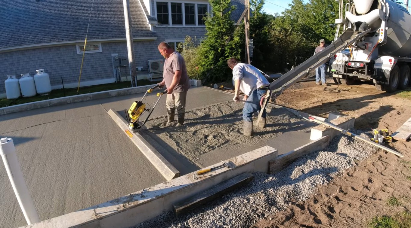 Professional concrete contractors smoothing freshly poured concrete